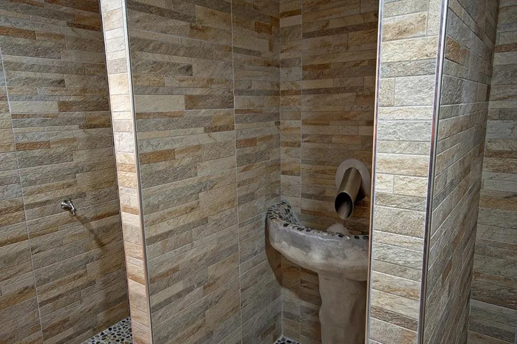 Doccia della zona benessere con rivestimento in pietra e getto emozionale