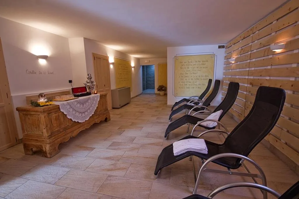 Area relax della spa con lettini reclinabili, pavimento in pietra e arredi in legno