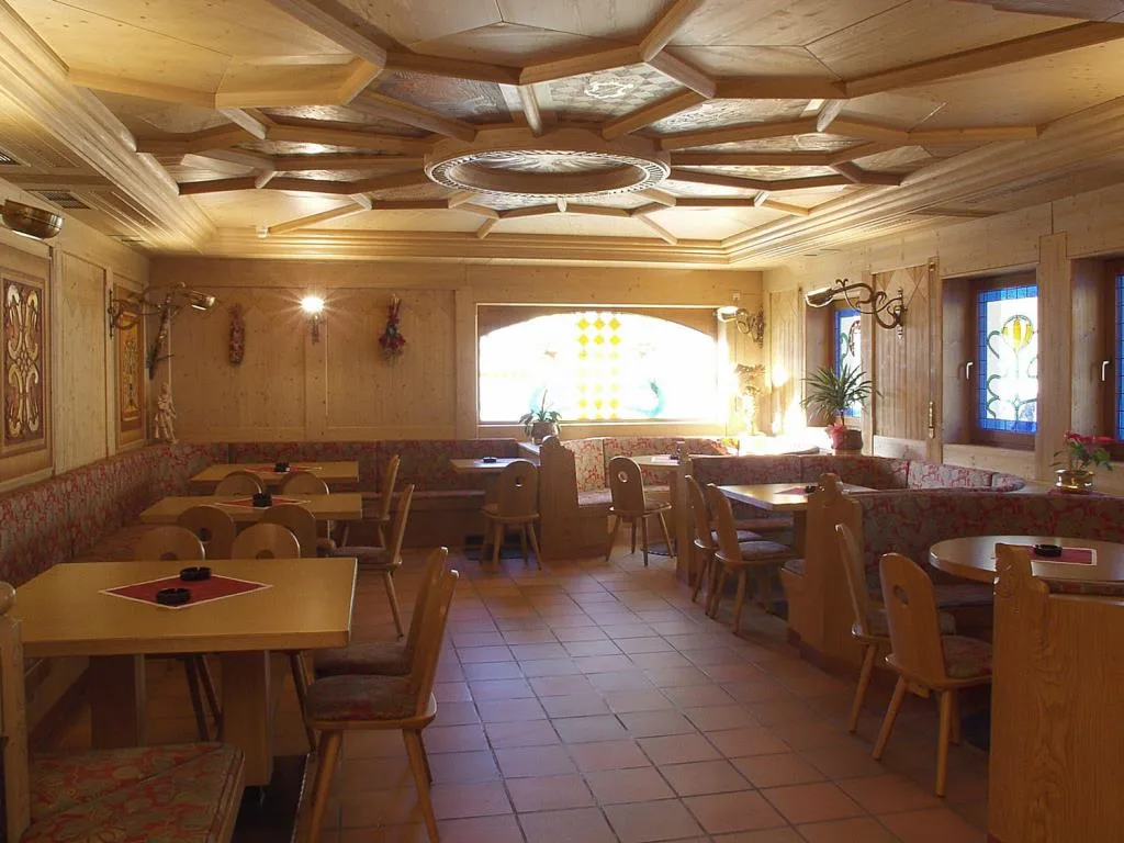 Sala da pranzo rustica con soffitto in legno intagliato e panche imbottite