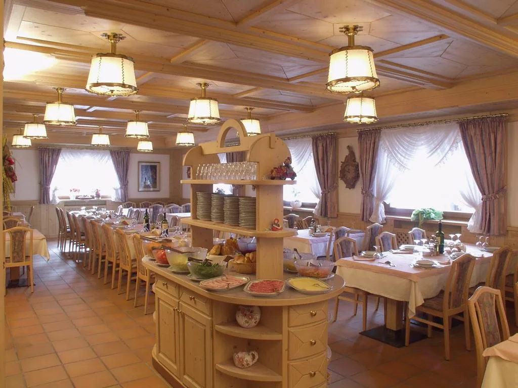 Sala ristorante con buffet centrale, tavoli apparecchiati e lampadari eleganti