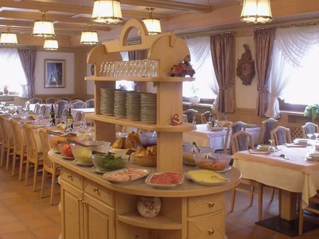 Buffet nella sala da pranzo con piatti, bicchieri e selezione di antipasti