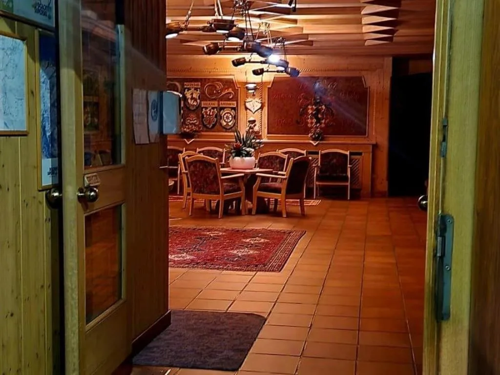 Ingresso con vista sulla sala soggiorno in legno e tappeti