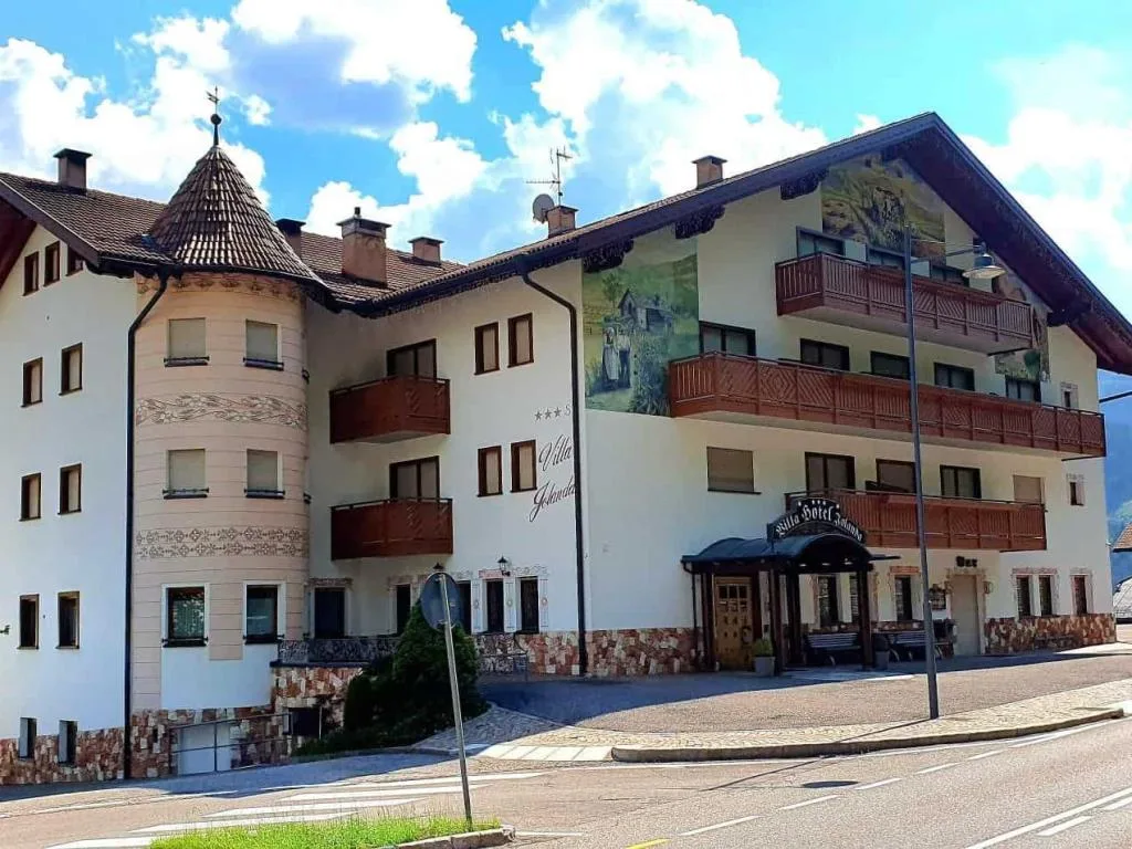 Facciata estiva dell'Hotel Villa Jolanda con torretta e affreschi decorativi
