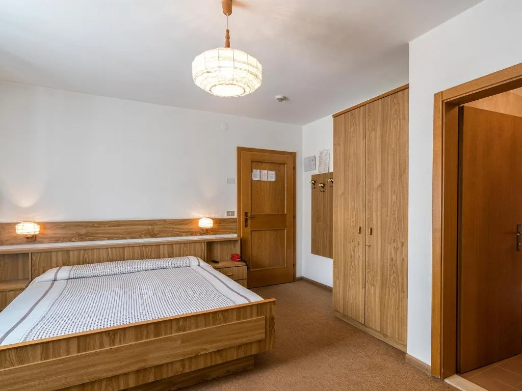 Camera da letto con letto matrimoniale, armadio in legno e ampi spazi