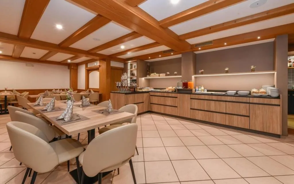 Sala colazione moderna con buffet e area ristorazione con travi in legno