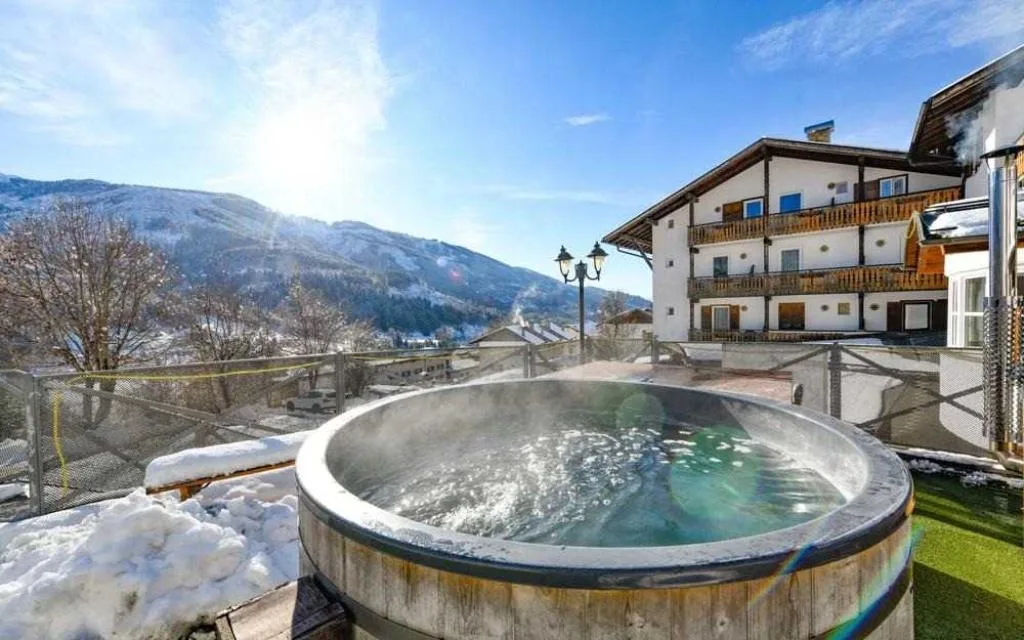 Vasca idromassaggio esterna a botte con vista sulle montagne innevate