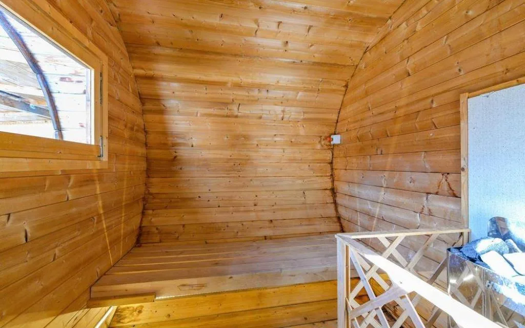 Interno di sauna finlandese in legno con stufa e finestra