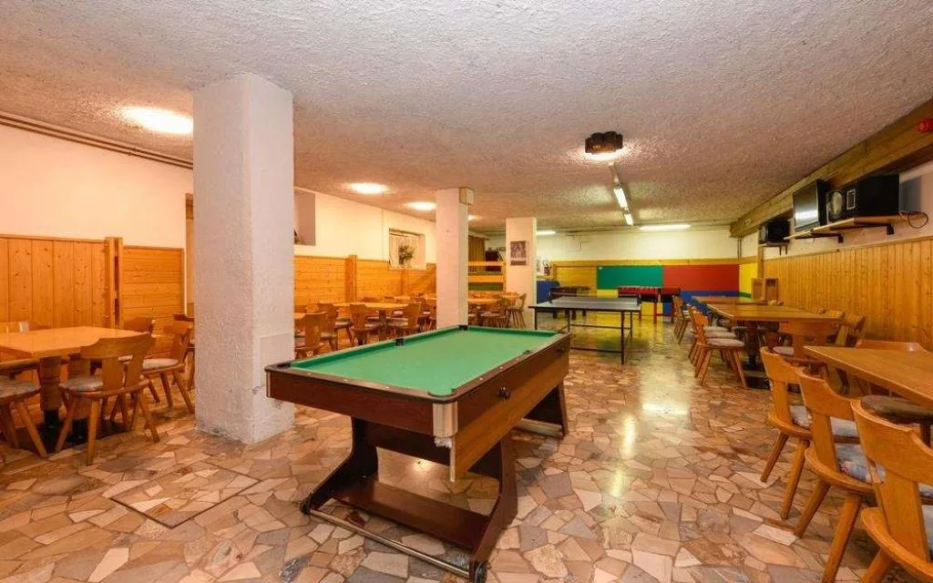 Sala giochi con biliardo, ping pong e tavoli in legno