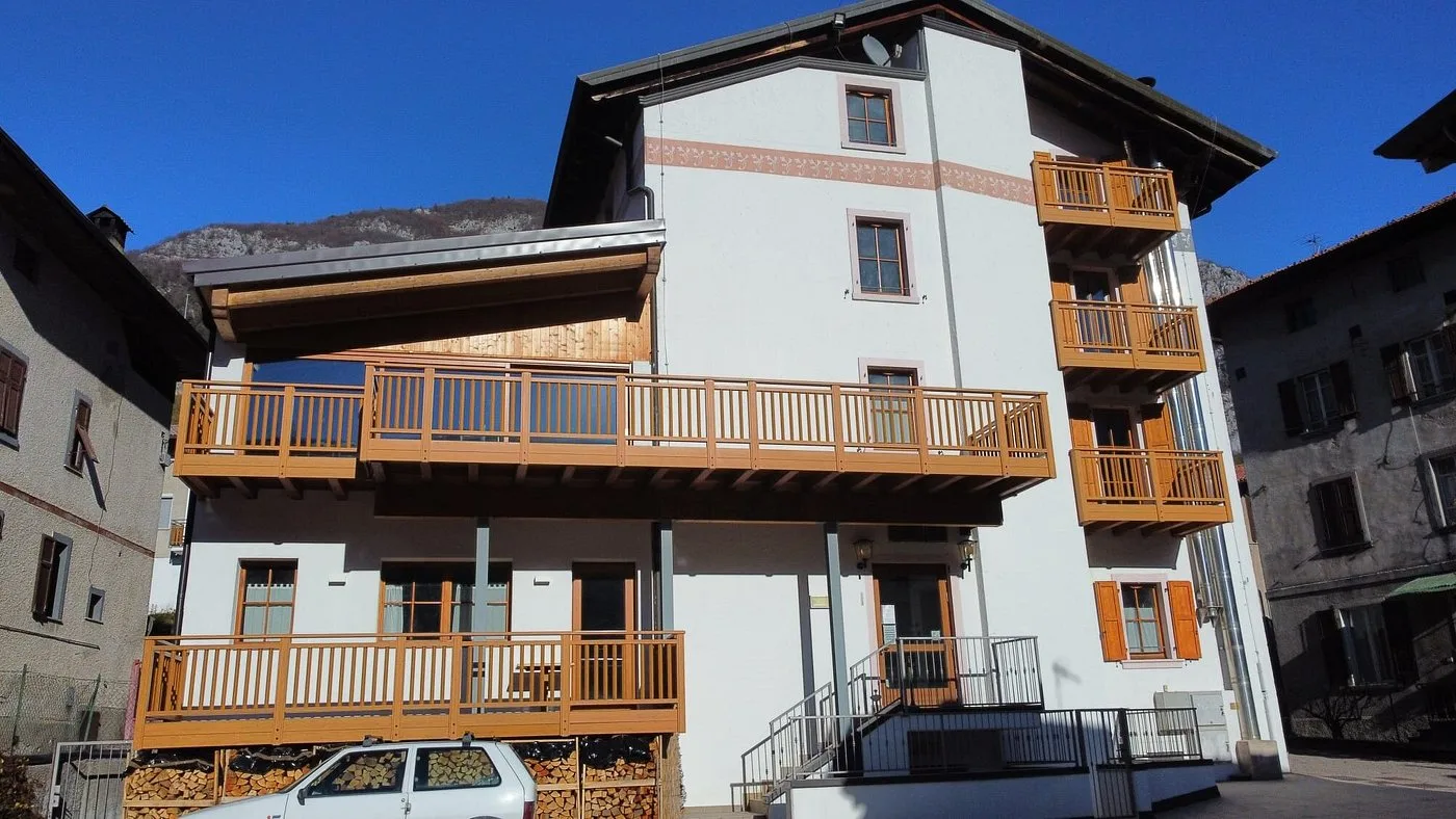 Facciata dell'hotel con ampie terrazze in legno e legna accatastata