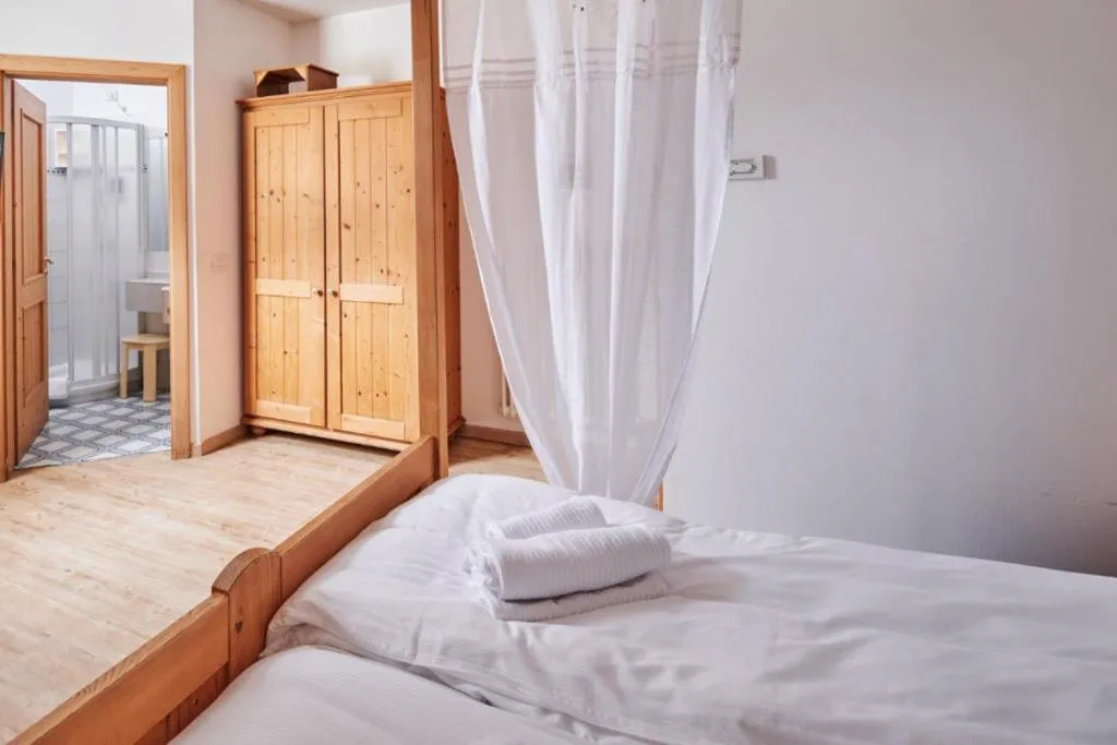 Camera con letto a baldacchino, armadio in legno e bagno privato con doccia