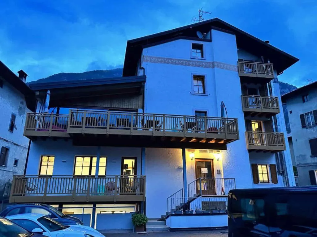 Facciata dell'edificio con balconi in legno illuminata al crepuscolo