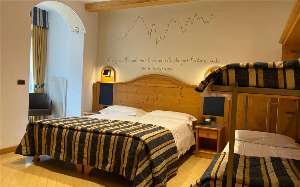 Camera familiare con letto matrimoniale, letto a castello e decorazione a tema montagna