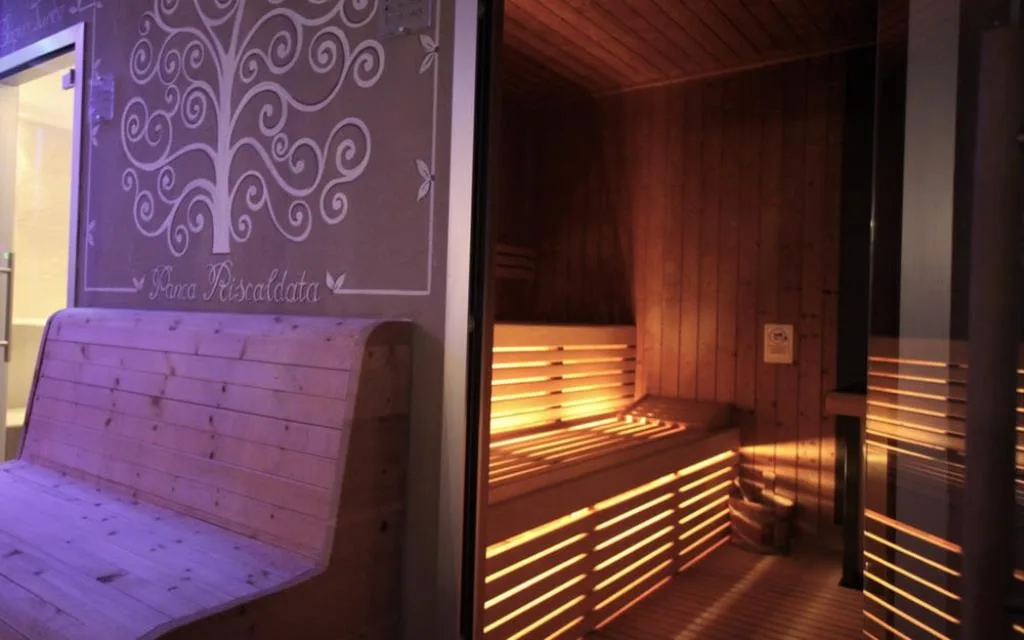 Sauna finlandese in legno con panca riscaldata e illuminazione soffusa