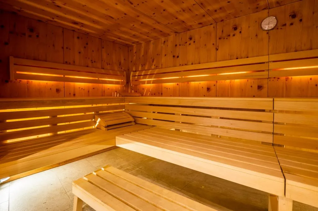 Interno della sauna finlandese in legno con panche e illuminazione soffusa