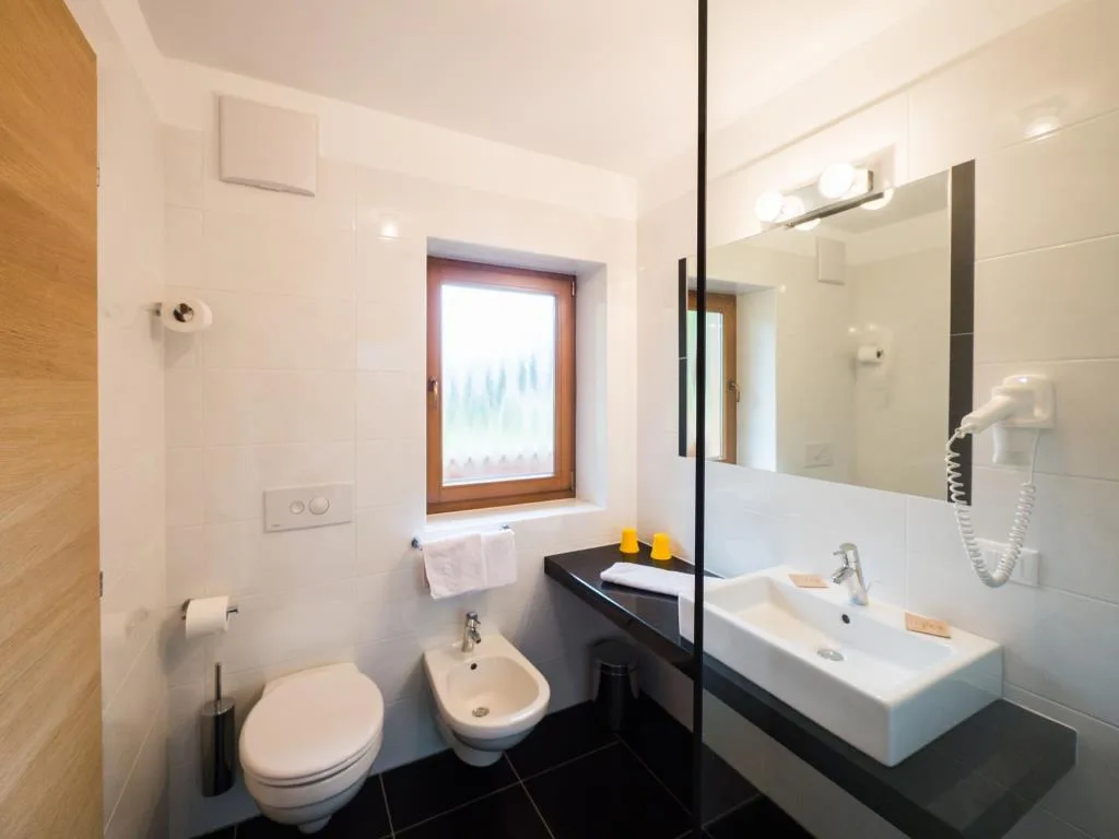 Bagno moderno con lavabo, wc, bidet e piastrelle nere