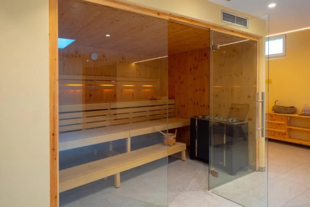 Sauna finlandese in legno di cirmolo con parete in vetro