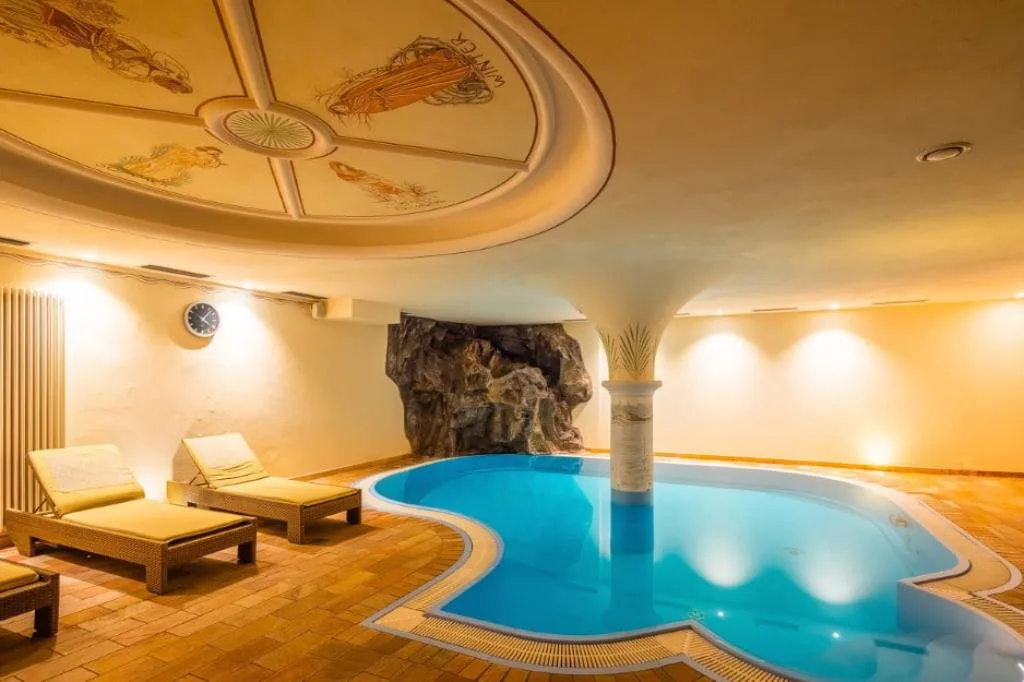 Piscina interna con soffitto affrescato, colonna e grotta rocciosa