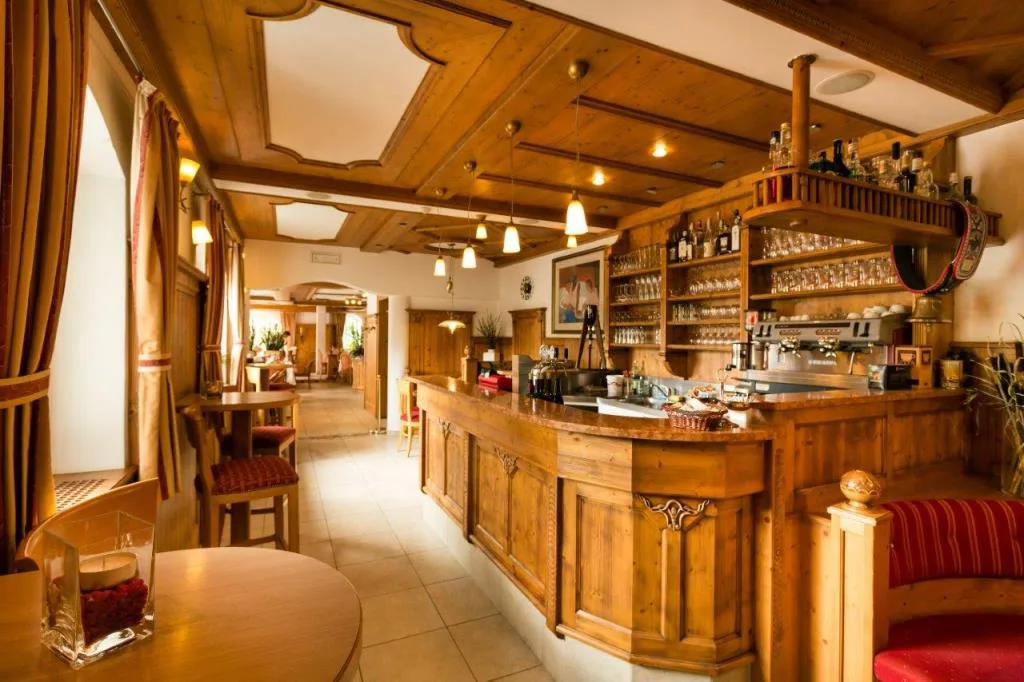 Bar interno dell'hotel con bancone in legno e soffitto a cassettoni