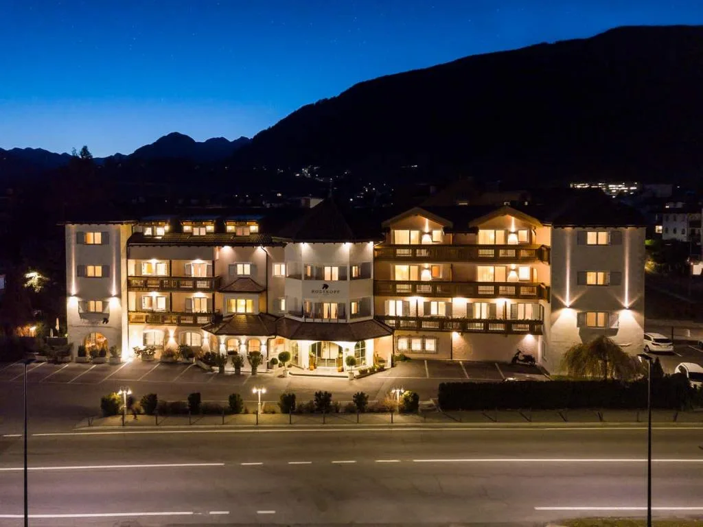 Vista notturna aerea dell'hotel illuminato con montagne sullo sfondo