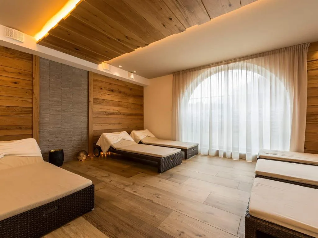 Zona relax spa con lettini e ampia finestra ad arco luminosa