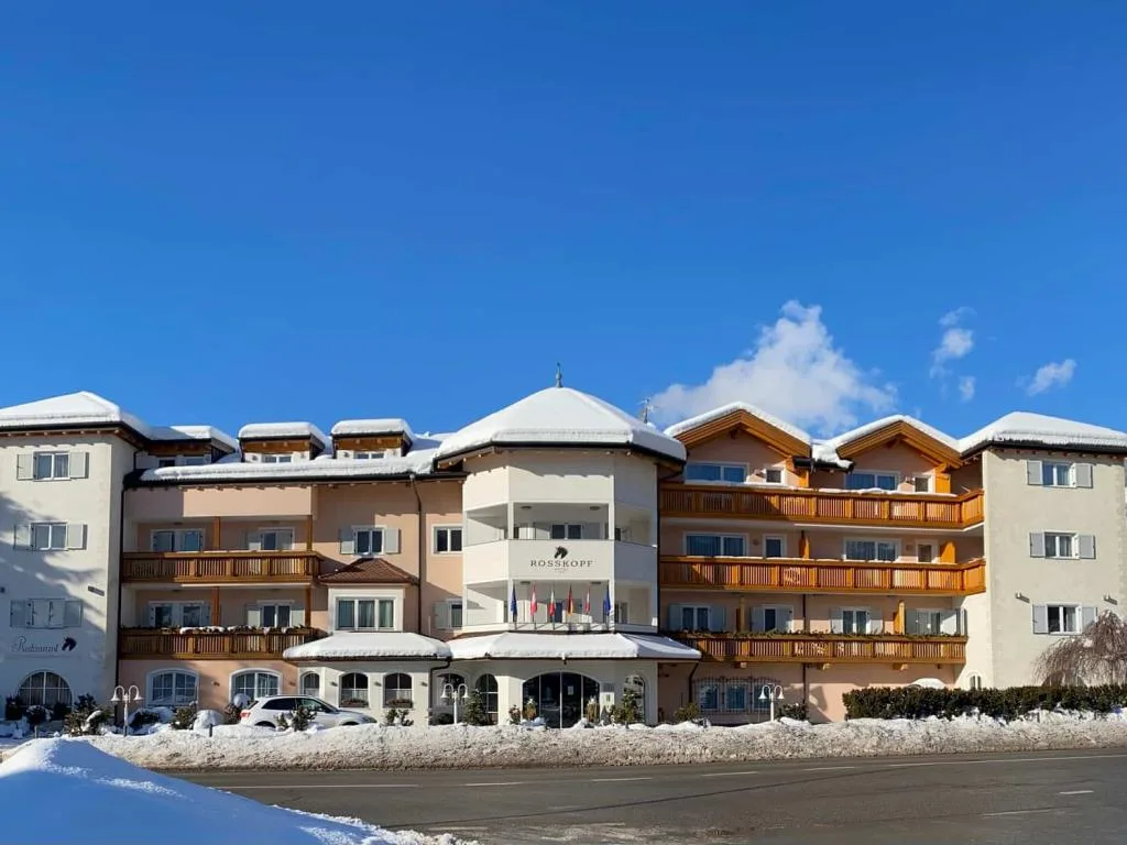 Facciata dell'hotel Rosskopf innevata sotto cielo azzurro limpido