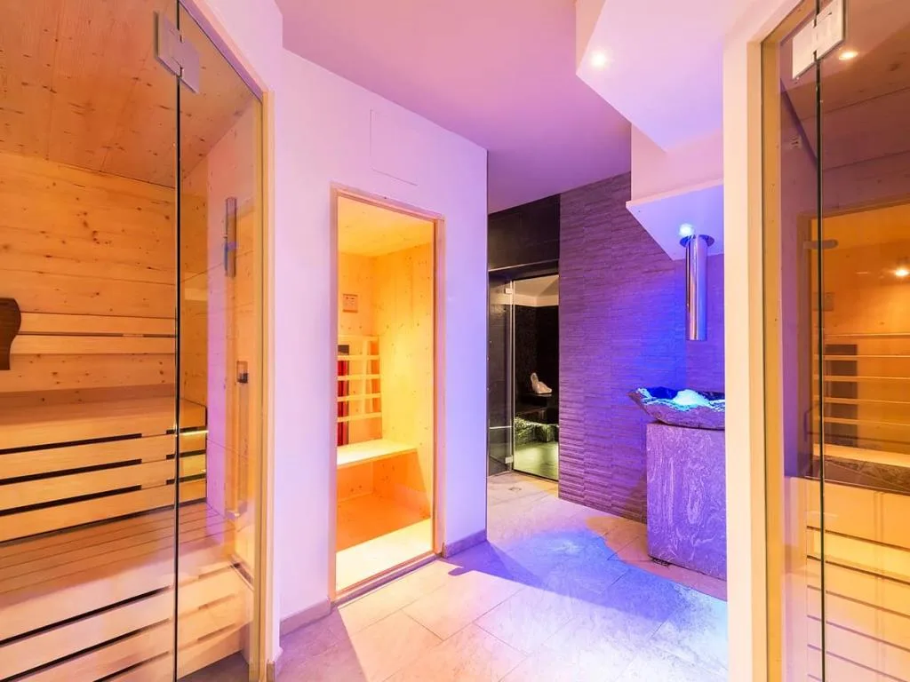 Zona spa con saune in legno, bagno turco e illuminazione colorata