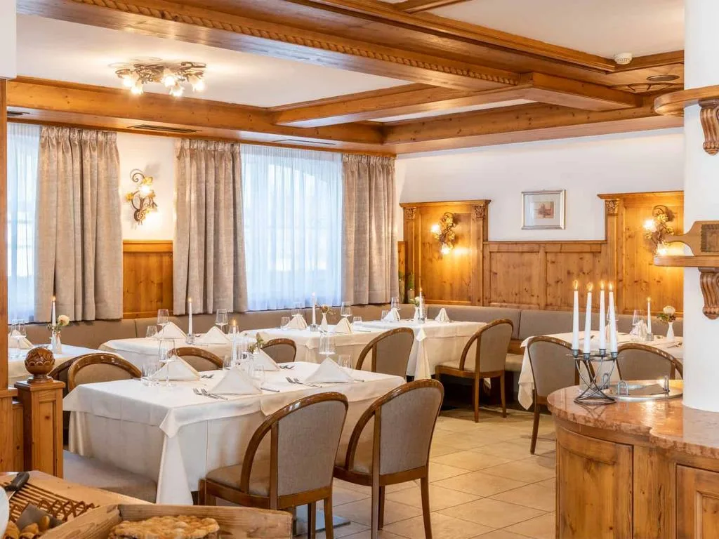 Sala ristorante elegante con tavoli apparecchiati e boiserie in legno