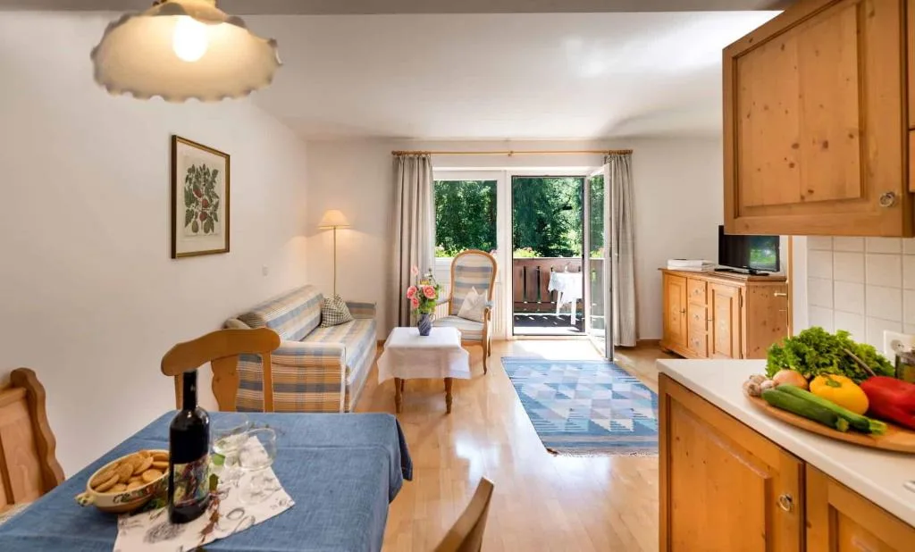Soggiorno di appartamento con cucina, divano e accesso al balcone