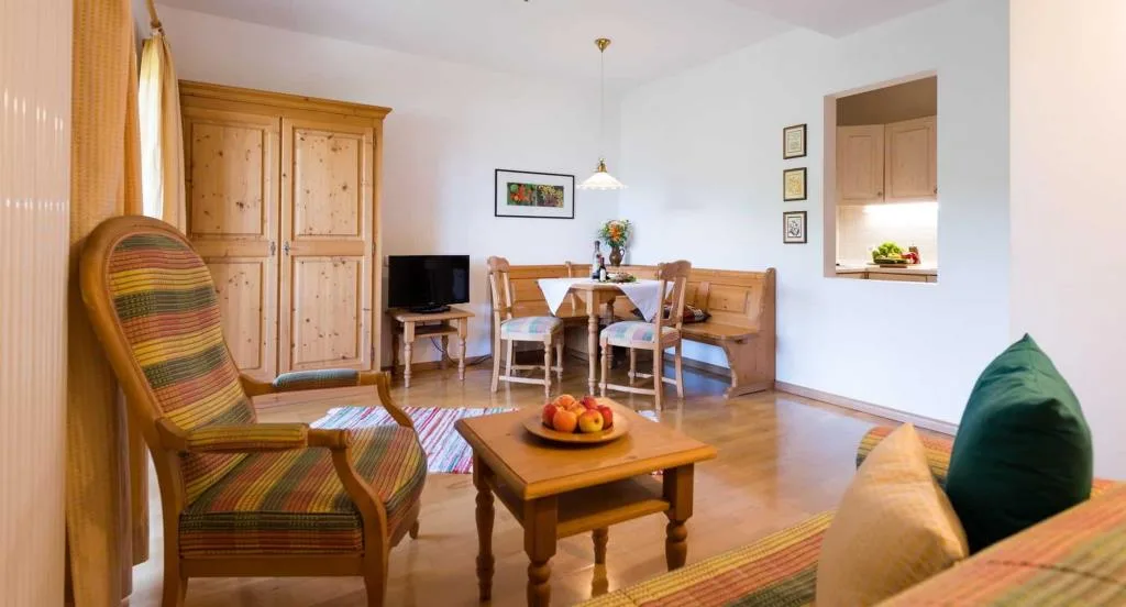 Salottino di appartamento con poltrona, tavolo e angolo pranzo in legno