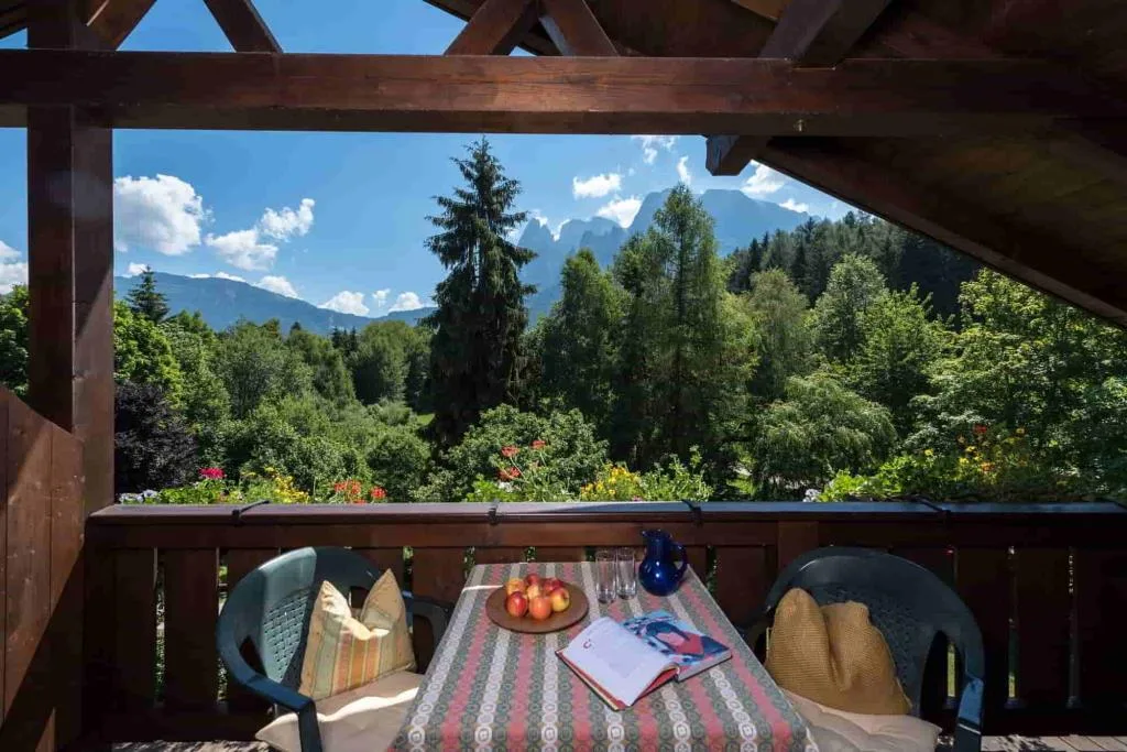 Balcone con tavolo e vista panoramica sulle montagne e sul verde
