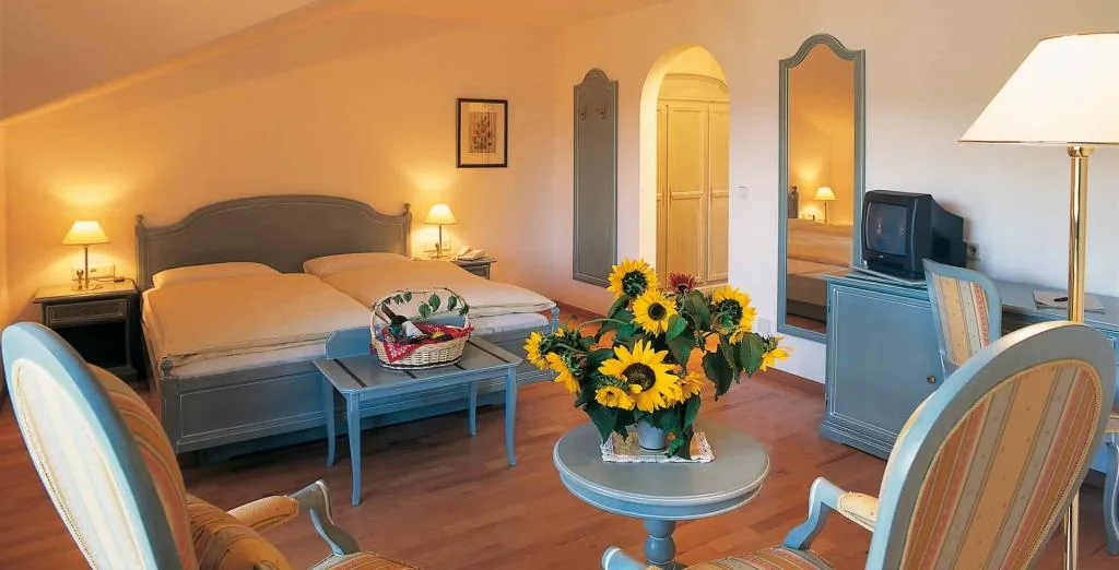 Camera matrimoniale con arredi azzurri, girasoli e area soggiorno