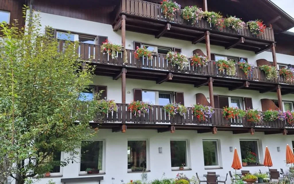 Balconi in legno decorati con fiori colorati e ombrelloni