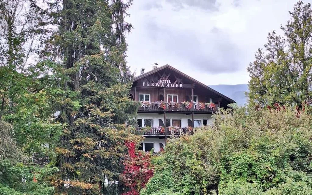 Hotel Perwanger tra la vegetazione con insegna sul tetto